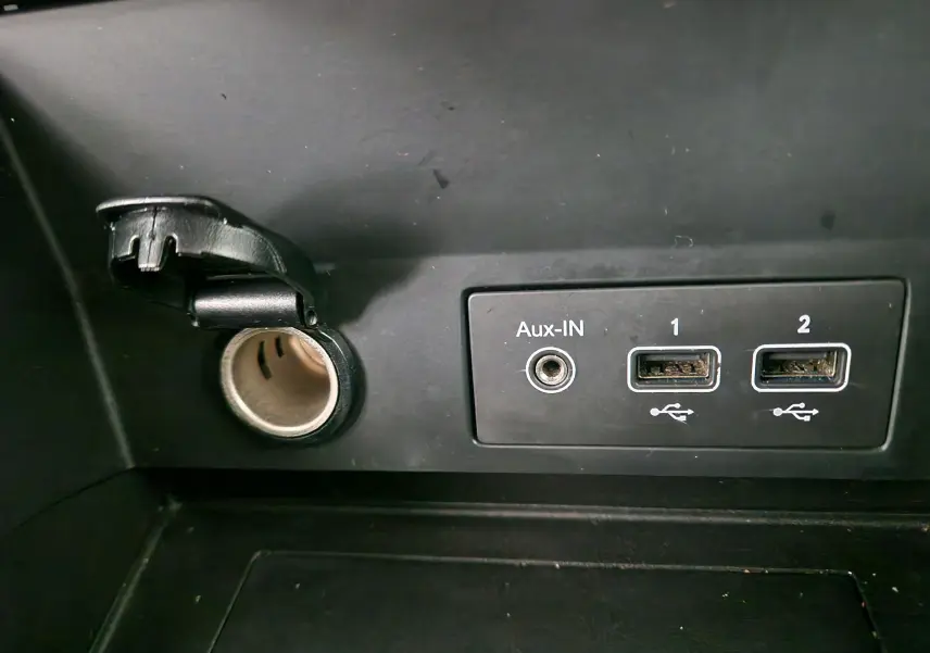 Prise allume-cigare ouverte avec ports Aux-IN et deux USB intégrés sur tableau de bord noir du Renault Captur 2020.