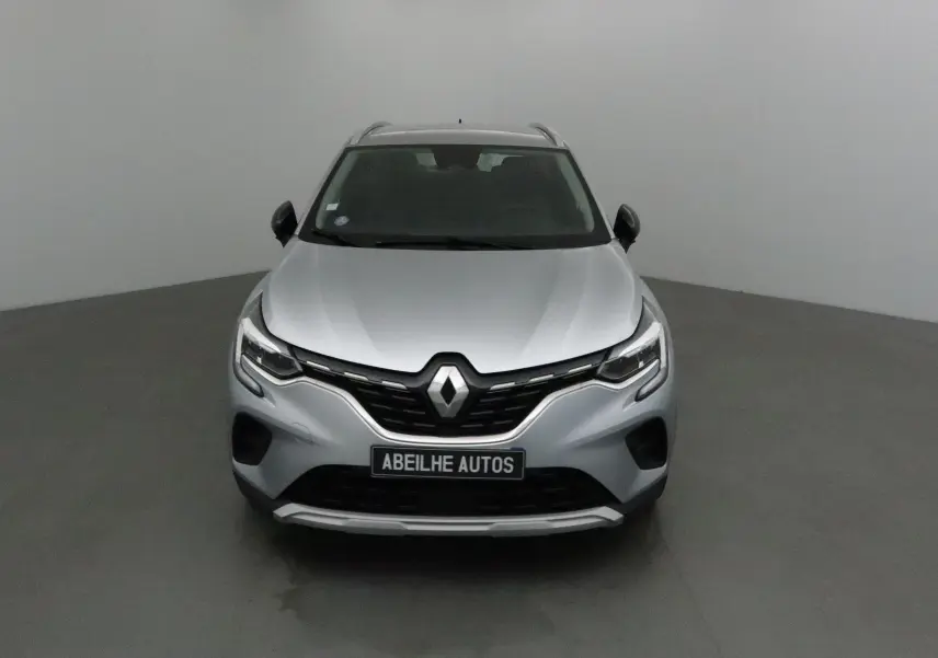 Vue frontale d'un Renault Captur gris Highland 2020 avec calandre noire et logo Renault bien visible.
