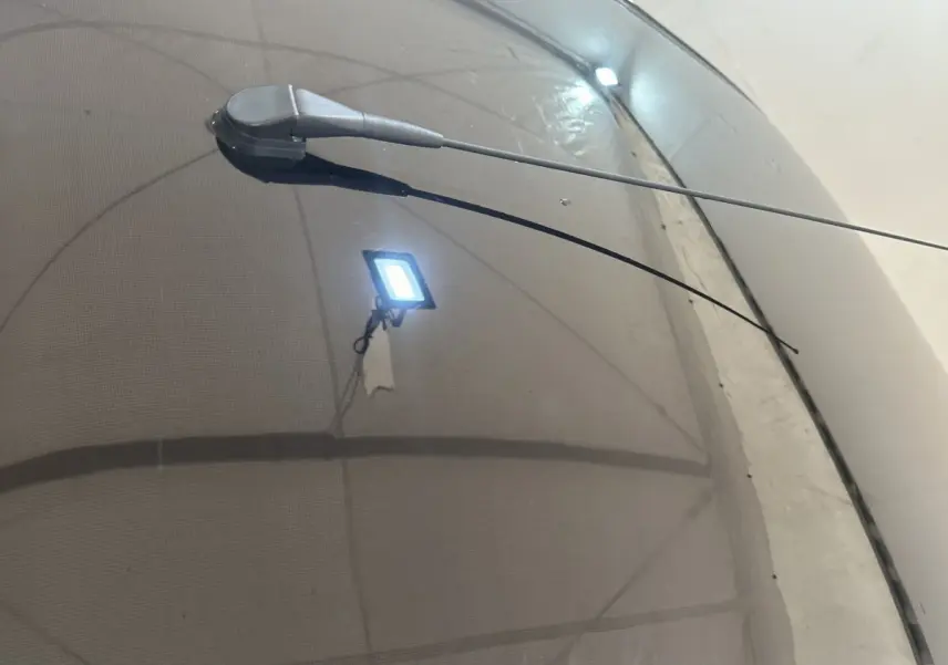 Gros plan sur l'antenne radio noire sur le toit d'une Aixam Ambition rouge, vue en légère plongée.