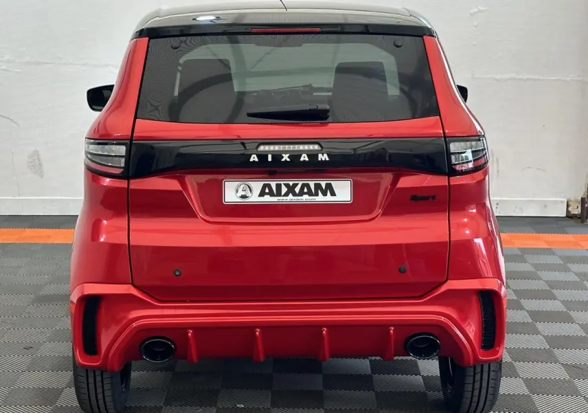 Vue arrière d'une Aixam Ambition 0.5 City Sport rouge 2026 avec diffuseur sport et feux arrière noirs.