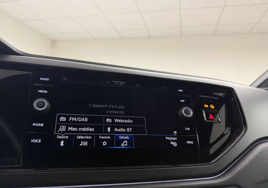 Vue rapprochée de l’écran multimédia noir du Volkswagen Taigo 1.5 TSI 150 DSG7 R-Line Edition, intérieur moderne.