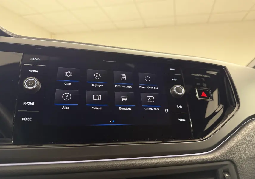 Écran tactile central du Volkswagen Taigo 2025, affichant le menu principal avec finition R-Line et tableau de bord noir.