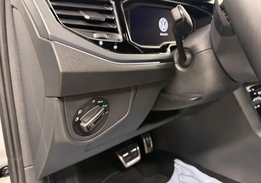 Gros plan sur le tableau de bord côté gauche du Volkswagen Taigo 2025, avec commandes d’éclairage et pédales en aluminium.