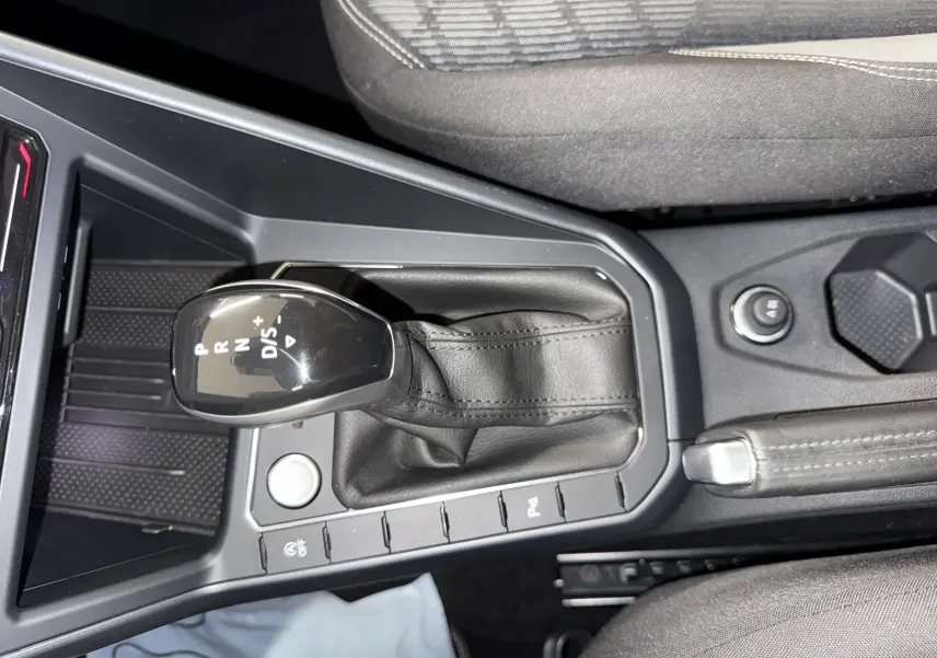 Le levier de vitesses automatique noir du Volkswagen Taigo 1.5 TSI 150 DSG7 R-Line Edition vu de dessus, avec console centrale grise.