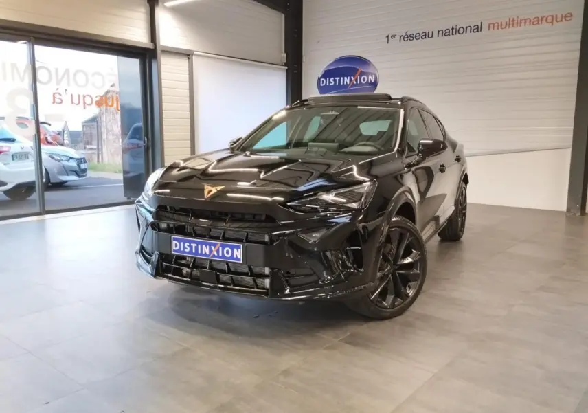 Vue 3/4 avant d'un CUPRA Formentor noir métal avec jantes alliage noires, dans un showroom lumineux.