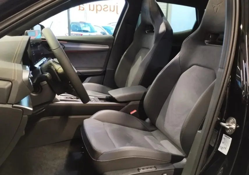 Vue intérieure côté conducteur du CUPRA Formentor noir métal 2026, sièges baquets suédine et cuir avec logo Cupra embossé.