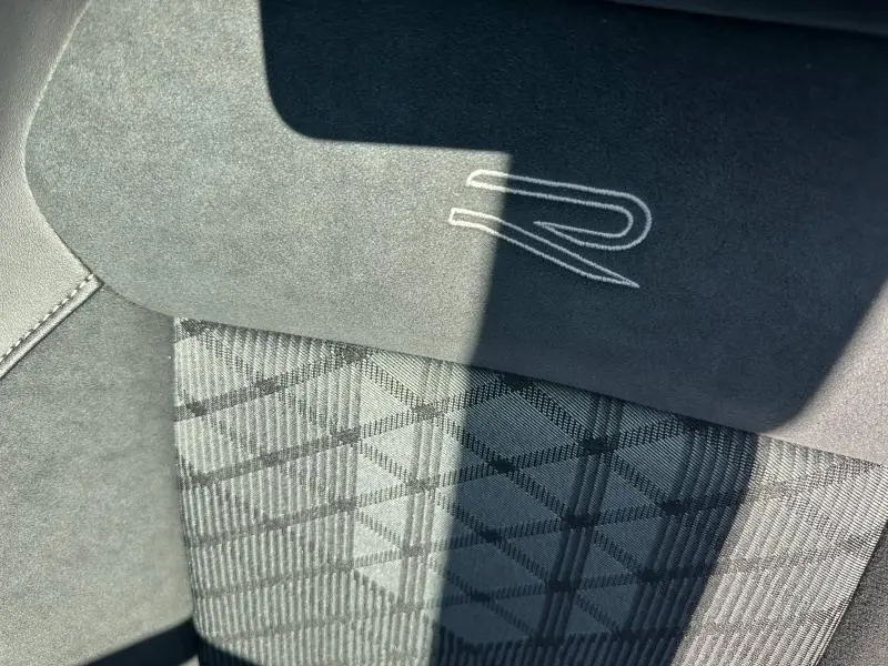 Détail du siège avant gris foncé avec logo R brodé et tissu à motif géométrique dans un Volkswagen T-Cross R-Line 2026.