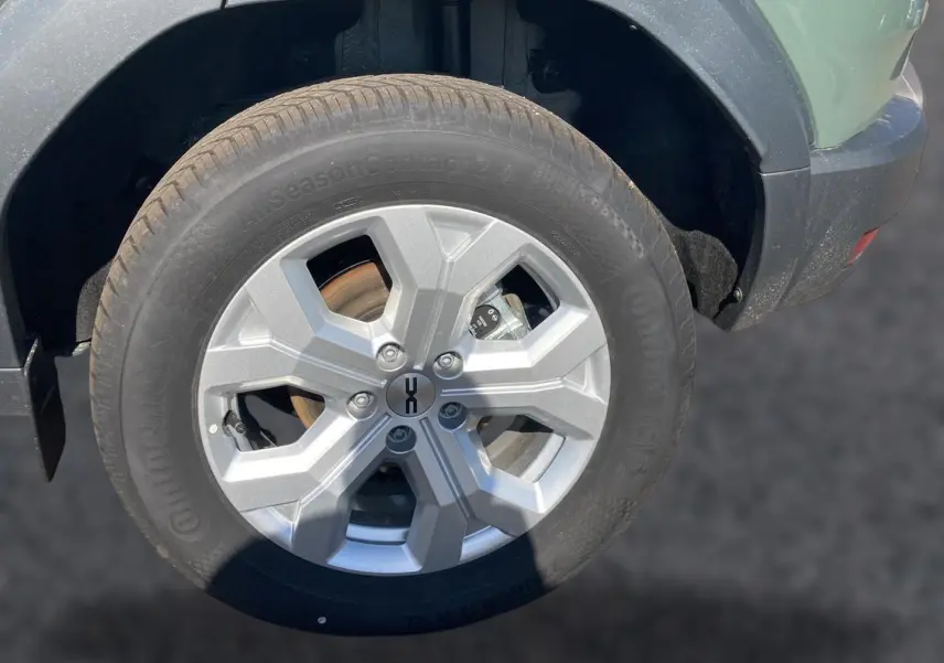 Gros plan sur la roue avant droite du Dacia Duster 2026 kaki lichen, avec jante alu et partie de l'aile visible.