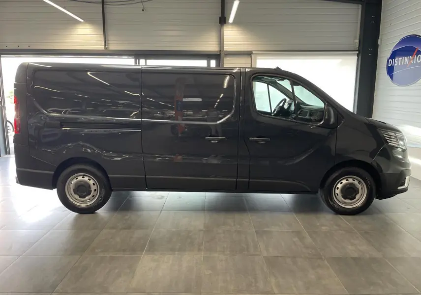 Profil droit du Renault Trafic Fourgon L2H1 2025 en gris comète, avec jantes tôles et porte coulissante fermée.