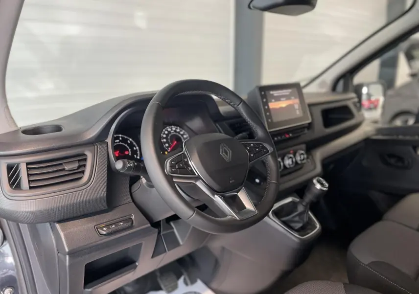 Intérieur du Renault Trafic Fourgon gris Comète, vue côté conducteur sur volant, tableau de bord et écran tactile.