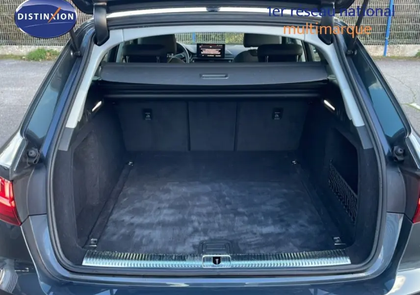 Coffre ouvert vu de l'arrière d'une Audi A4 Avant gris Manhattan, montrant un espace de chargement propre et spacieux.