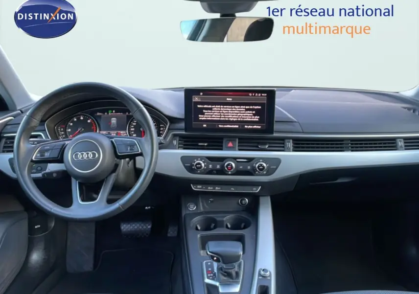 Vue intérieure de l'Audi A4 Avant 2021, tableau de bord moderne avec écran central et volant multifonction noir.