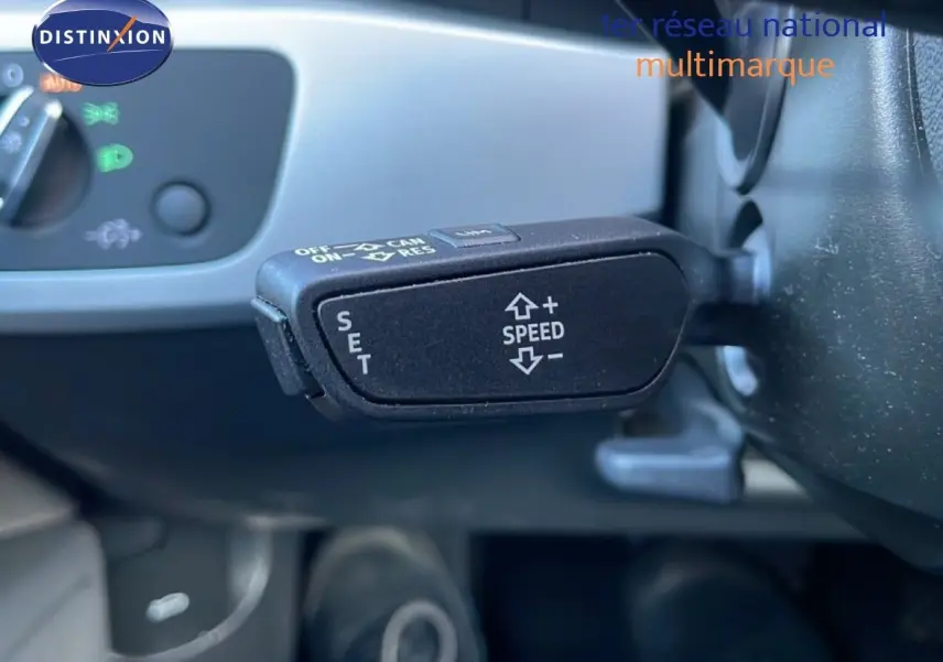 Gros plan sur la commande de régulateur de vitesse au volant d'une Audi A4 Avant gris Manhattan, intérieur visible.