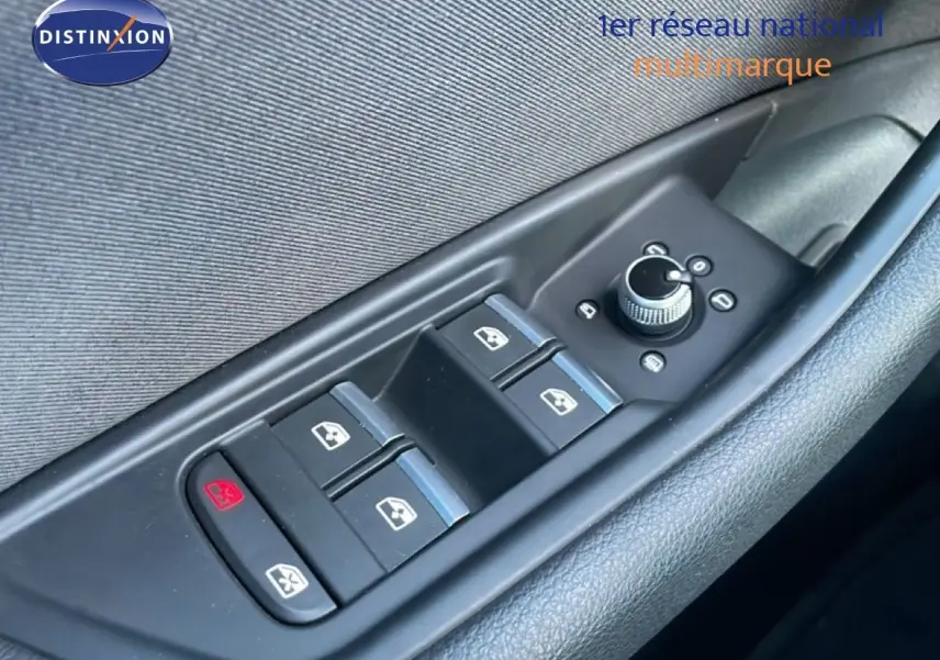 Gros plan sur les commandes des vitres électriques et rétroviseurs sur la porte côté gauche d'une Audi A4 Avant gris Manhattan.