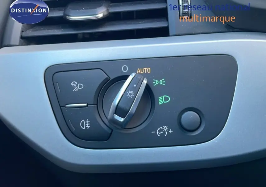 Gros plan sur la commande des phares de l'Audi A4 Avant 2021, finition Business Line, avec éclairage automatique activé.