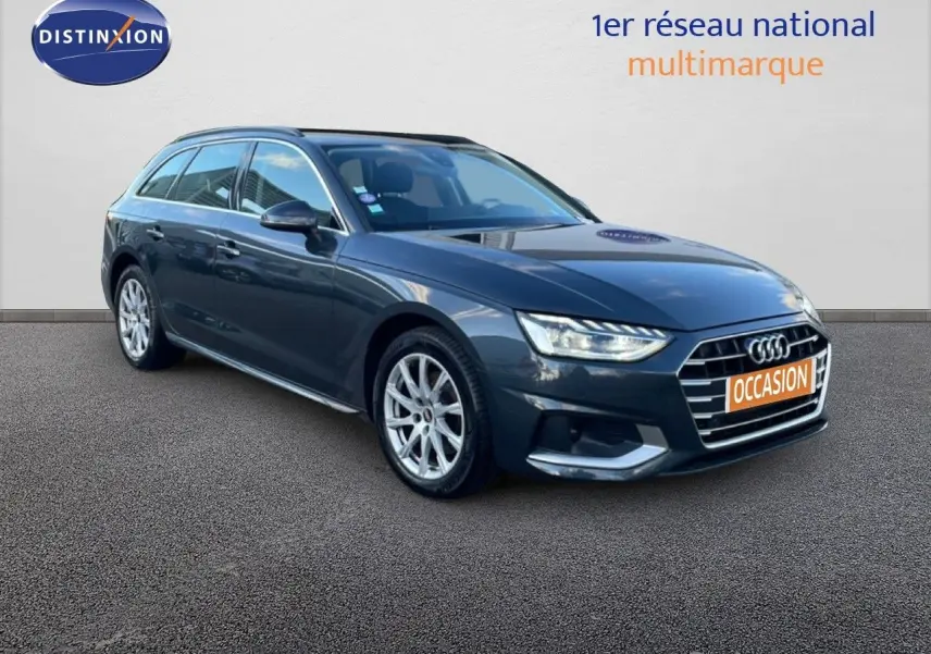 Audi A4 Avant gris Manhattan vue 3/4 avant droit avec calandre distinctive et feux LED allumés.