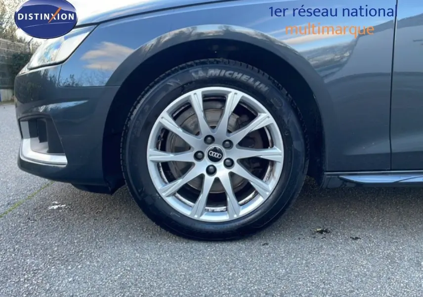 Gros plan sur la roue avant gauche d'une Audi A4 Avant gris Manhattan, mettant en valeur la jante en alliage et le pneu Michelin.
