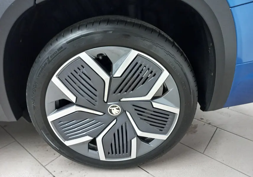 Gros plan sur la jante alliage 20'' Rila anthracite avec enjoliveur noir du côté avant droit d’un Skoda Kodiaq Bleu RS.