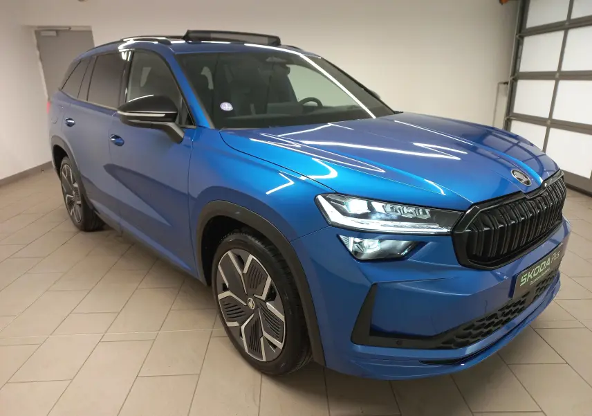 Vue 3/4 avant droit du Skoda Kodiaq 2024 Bleu RS avec calandre noire et jantes alliage 20 pouces anthracite.