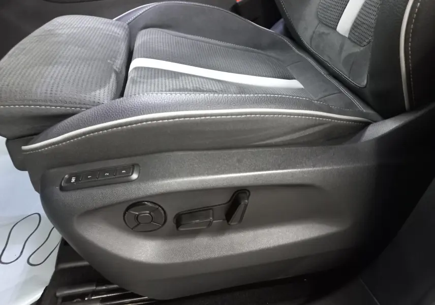 Gros plan sur le siège avant droit du Skoda Kodiaq 2024, revêtement noir avec surpiqûres blanches et commandes électriques.