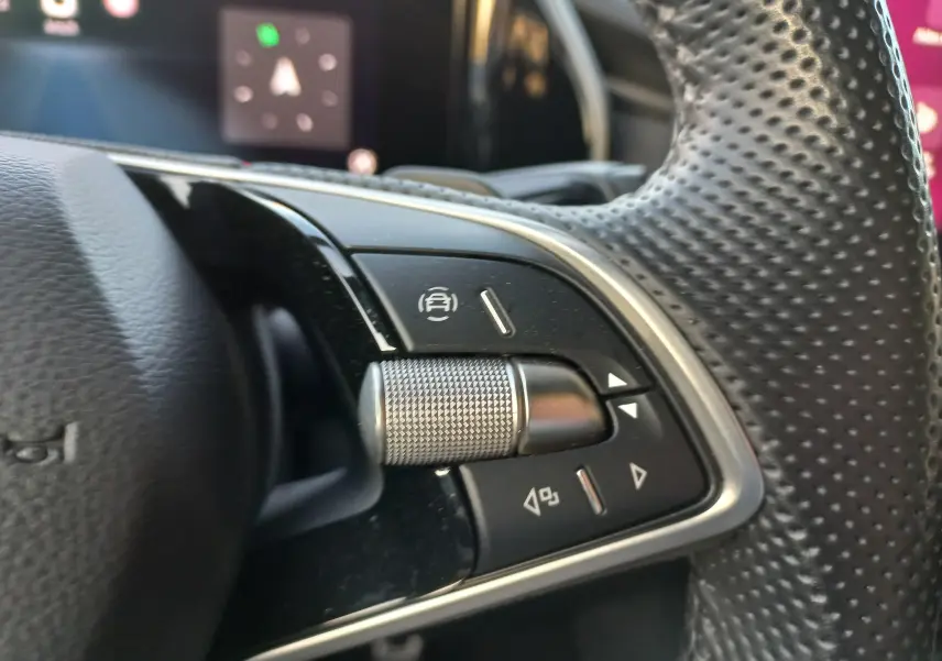 Détail intérieur côté gauche du tableau de bord du Skoda Kodiaq 2024, avec commandes d’éclairage et finition noire texturée.