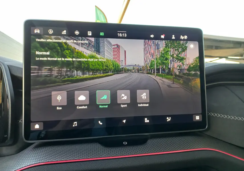 Écran tactile central du Skoda Kodiaq 2024 affichant les modes de conduite dans un intérieur avec surpiqûres blanches et liseré rouge.