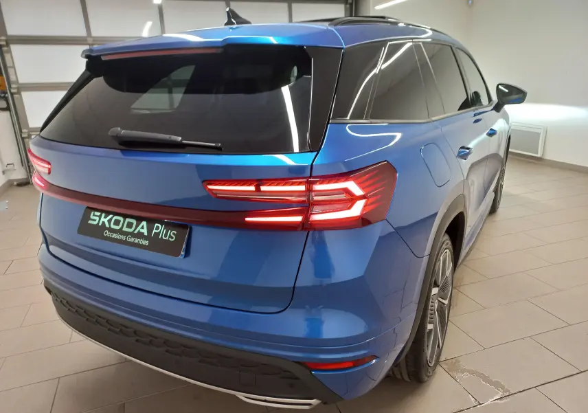 Vue 3/4 arrière droite du Skoda Kodiaq 2024 Bleu RS avec feux arrière LED et toit panoramique ouvrant.
