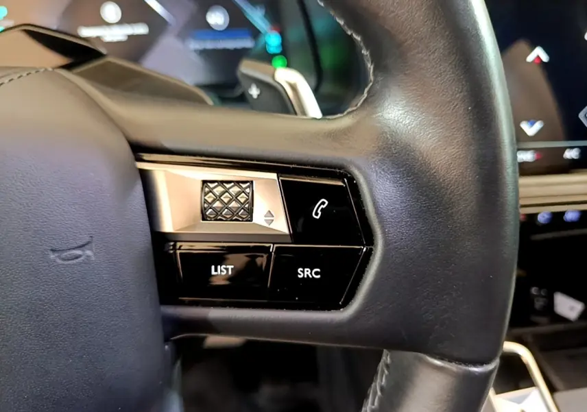 Gros plan sur les commandes gauche du volant cuir noir du DS7 Crossback E-TENSE 4x4 300 gris foncé, avec touches multifonctions.