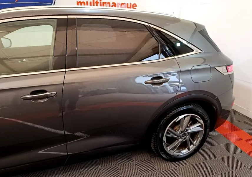 Vue latérale droite du DS7 Crossback E-TENSE gris foncé, mettant en valeur la porte arrière et la roue arrière avec jante design.