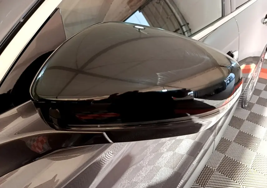 Gros plan sur le rétroviseur noir brillant côté conducteur du DS7 Crossback E-TENSE gris foncé, vue latérale droite.