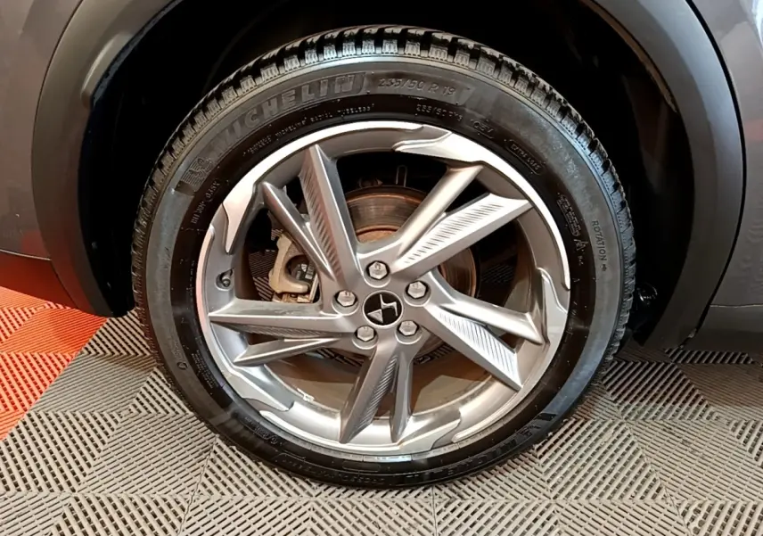 Gros plan sur la roue avant droite gris foncé du DS7 Crossback E-TENSE 4x4 300 avec jante alliage distinctive.