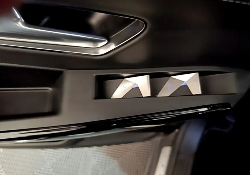 Détail des commandes de réglage des rétroviseurs sur la porte côté conducteur du DS7 Crossback gris foncé.