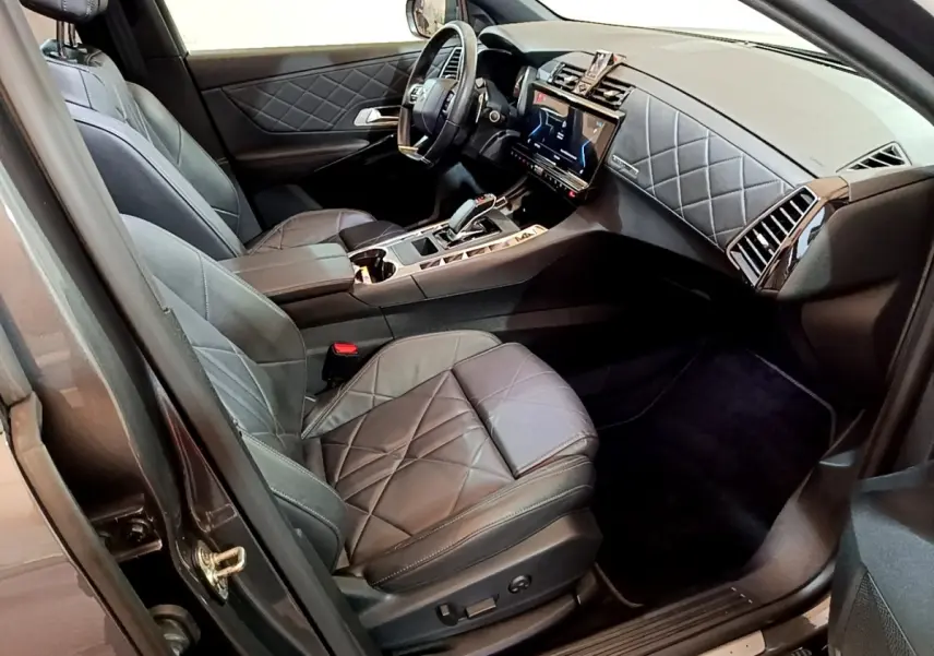 Vue intérieure côté conducteur du DS7 Crossback E-TENSE 4x4 300 RIVOLI 2021, cuir gris foncé matelassé et tableau de bord moderne.