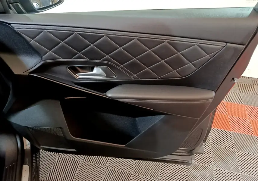 Vue intérieure du panneau de porte côté gauche en cuir noir matelassé du DS7 Crossback E-TENSE 4x4 gris foncé.