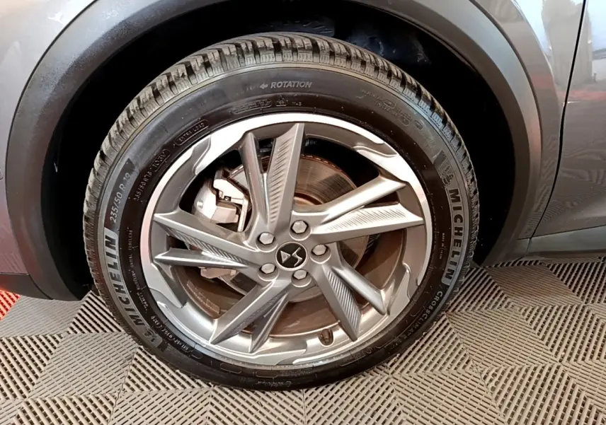 Gros plan sur la roue arrière droite d’un DS7 Crossback E-TENSE gris foncé avec pneu Michelin visible.
