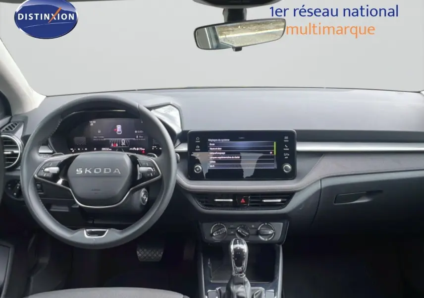 Intérieur de la Skoda Fabia 2025 en gris graphite, vue frontale du tableau de bord avec écran tactile et volant multifonction.