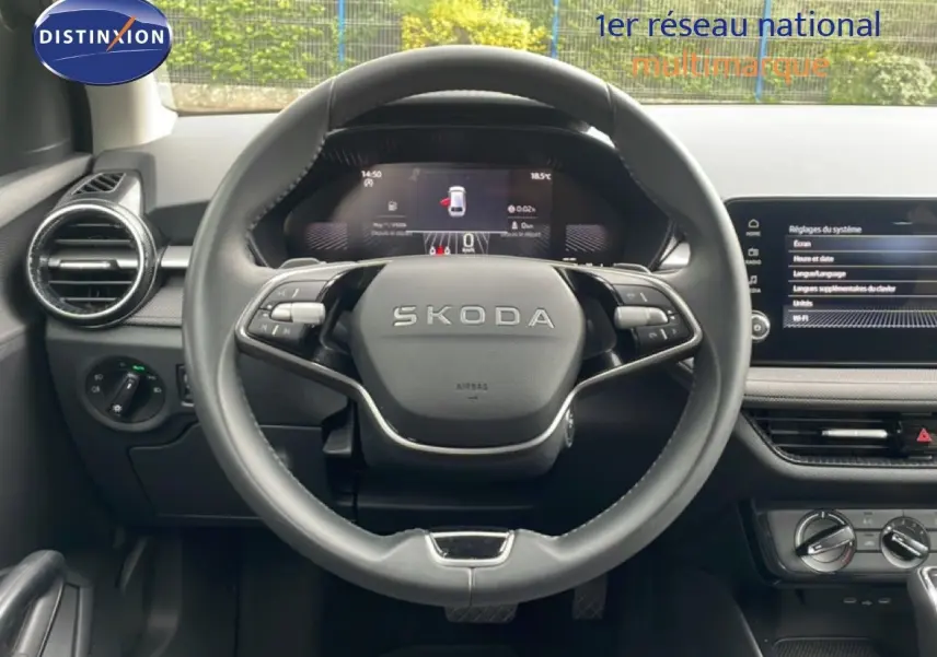 Vue centrée sur le volant noir de la Skoda Fabia 2025 avec tableau de bord numérique et écran tactile à droite.