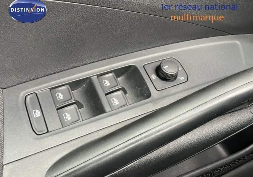 Gros plan sur les commandes de lève-vitres et réglage des rétroviseurs côté conducteur d'une Skoda Fabia gris graphite.