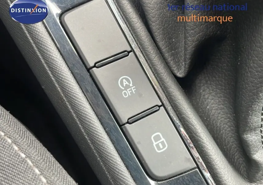 Gros plan sur les boutons de commande près du levier de vitesses dans une Skoda Fabia gris graphite, intérieur noir.