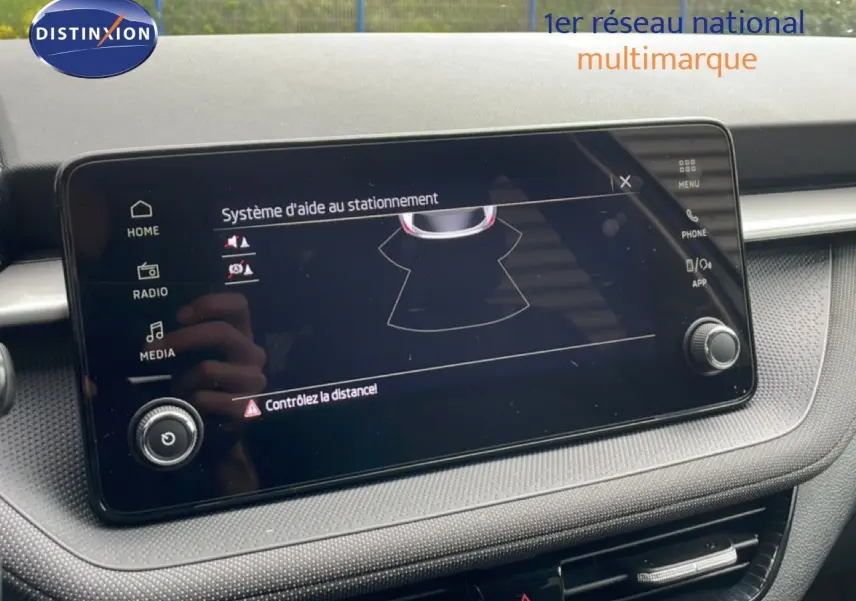 Écran tactile du système d'aide au stationnement dans l'habitacle gris noir de la Skoda Fabia 2025.