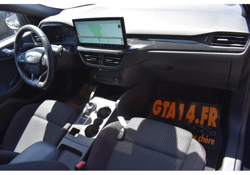 Vue intérieure côté conducteur de la Ford Focus SW 2025, tableau de bord noir avec écran tactile et volant multifonction.