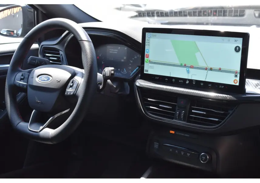 Vue intérieure côté conducteur de la Ford Focus SW 2025 avec tableau de bord numérique et écran tactile central affichant la navigation.