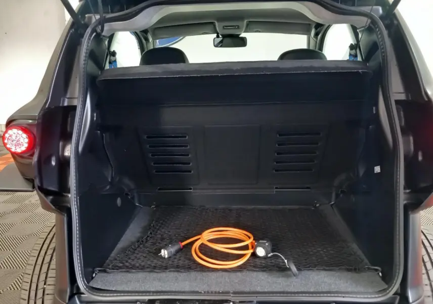 Vue arrière du coffre ouvert d’une Aixam Mega E-Scouty Evo bleu 2026 avec câble de recharge orange visible.