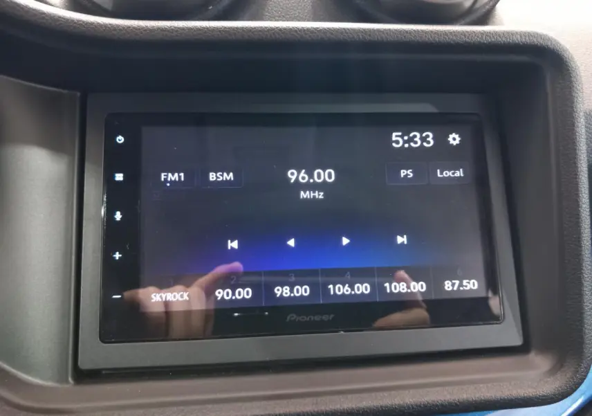 Écran tactile multimédia Pioneer dans l'habitacle de l'AIXAM MEGA bleu, affichant une radio FM à 96 MHz.