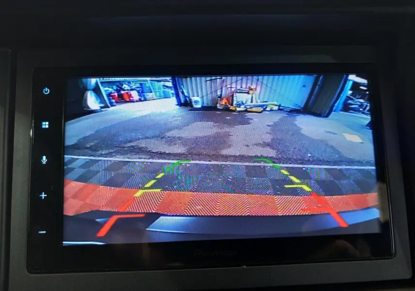 Vue de la caméra de recul côté conducteur de l'AIXAM MEGA E-SCOUTY EVO bleu, affichée sur l'écran intérieur.