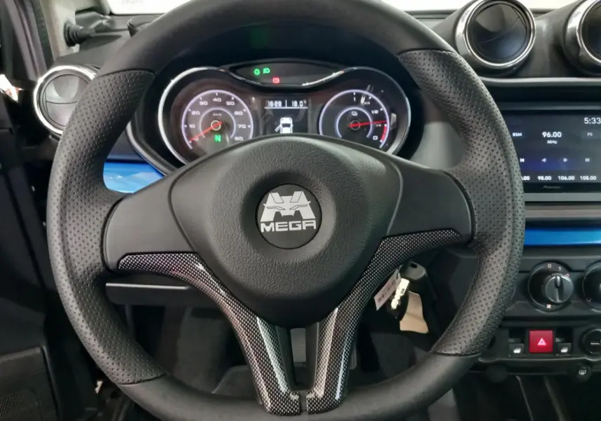 Vue intérieure centrée sur le volant perforé noir avec logo MEGA, tableau de bord et écran multimédia d'une Aixam Mega bleu.