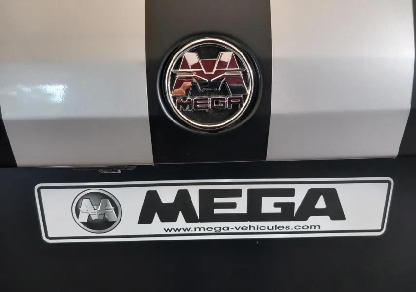 Gros plan sur l'arrière du véhicule bleu AIXAM MEGA avec logo et plaque d'immatriculation MEGA visible.