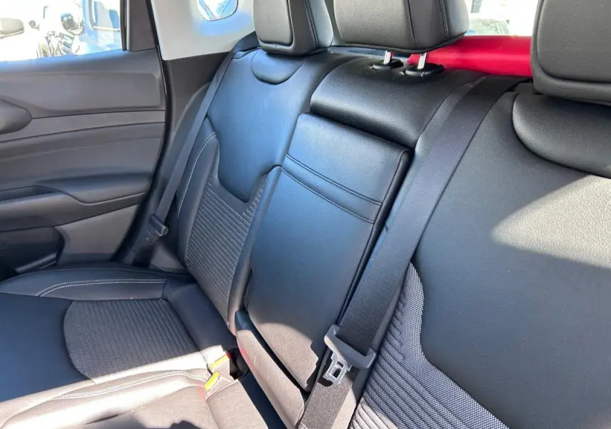 Vue intérieure côté droit des sièges arrière en cuir noir du Jeep Compass 2024 avec accoudoir central rabattable.