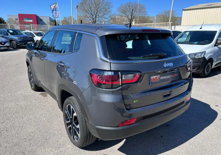 Vue 3/4 arrière droite d'un Jeep Compass gris 2024 avec jantes alliage 18 pouces et feux arrière LED.