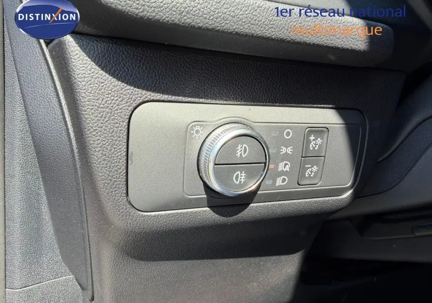 Gros plan sur le panneau de commande des phares à gauche du volant dans un Ford Kuga gris magnétique 2024.